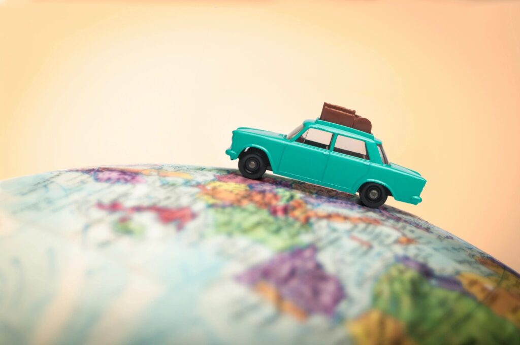 A toy car is on top of the globe.